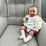 Elodie joined the competition — help win amazing prizes! baby, child, smiling, sitting, armchair, cardigan, dress, socks, indoor, face, person, happy, cute, infant, fabric, texture, comfort, home, furniture, cozy