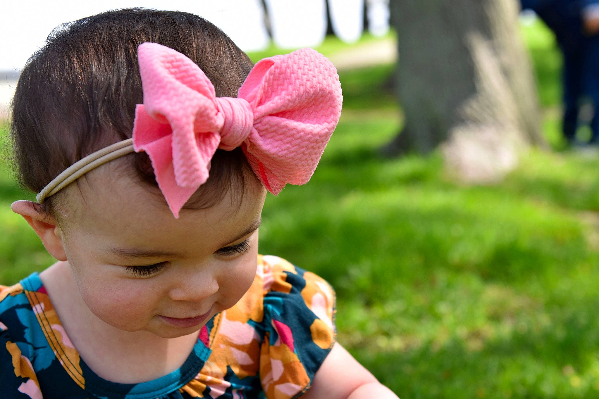 Eviana is registered to the contest to win money with this photo: auto_part, automotive_wheel_system, baby, child, ear, fashion_accessory, grass, hair_accessory, hair_tie, hand, headband, headgear, person, pink, plant, spring, toddler, wheel