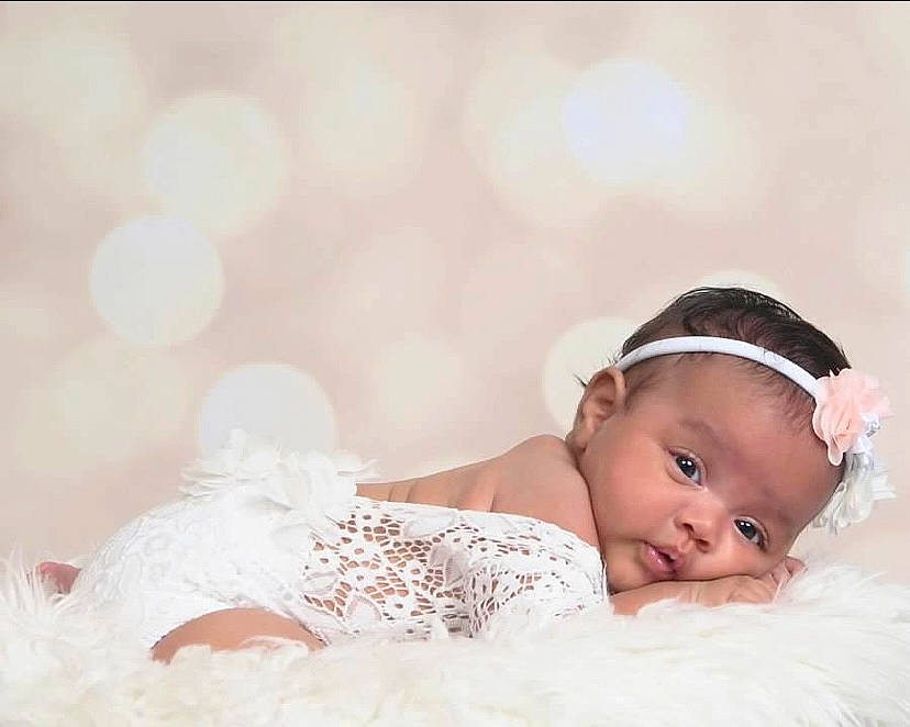 Amelia is registered to the contest to win money with this photo: baby, baby_toddler_clothing, child, comfort, embellishment, eye, eyelash, fashion_accessory, flash_photography, grass, hair_accessory, happy, headband, headpiece, jewellery, peach, person, photo_shoot, portrait_photography, sitting