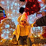 baby, child, winter_clothing, hat, gloves, boots, holiday_lights, decorations, festive, illumination, toy_bear, white, red, night, outdoor, person, holding_hand, warm_clothing, cute, seasonal