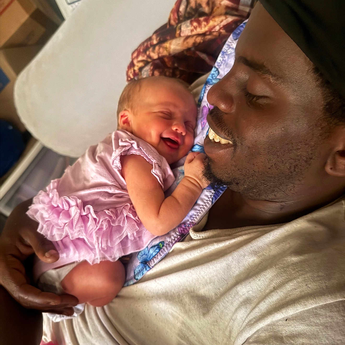 Heaven Faith is registered to the contest to win money with this photo: baby, man, smile, laugh, love, indoor, family, holding, child, clothing, pink, frilly, happy, face, skin, person, tender, joy, blanket, casual