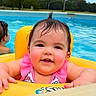 baby, child, pool, water, float, yellow, swimming, happy, smiling, wet_hair, outdoor, summer, fun, infant, pink_clothing, person, recreation, leisure, floating, background