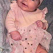Kinsley is registered to the contest to win money with this photo: baby, infant, smile, pink_clothing, bow_headband, blanket, cute, chubby_cheeks, sitting, soft_texture, portrait, child, adorable, happy, indoor, closeup, toddler, fashion, cute_outfit, cozy