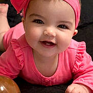 Kinsley is registered to the contest to win money with this photo: baby, infant, smiling, headband, bow, pink_outfit, rosy_cheeks, tooth, big_eyes, long_eyelashes, hand, toy, lying_down, portrait, close_up, indoor, blanket, happy, adorable, cute