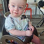 Landyn Scott joined the competition — help win amazing prizes! toddler, child, high_chair, blue_eyes, hot_wheels, tshirt, indoor, orange_chair, wood_floor, table, window, curious, seated, person, young_child, casual_clothing, daylight, furniture, smiling, cute