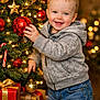 Landyn Scott joined the competition — help win amazing prizes! child, toddler, christmas_tree, ornaments, red_bauble, gold_bauble, star_decoration, candy_cane, presents, gift_boxes, holiday, festive, smiling, happy, jeans, hoodie, indoor, decorations, lights, celebration
