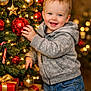 Landyn Scott joined the competition — help win amazing prizes! candy_cane, celebration, child, christmas_tree, cozy_clothing, festive, gift_box, gold_star, happy, holiday, holiday_lights, hoodie, indoor, jeans, ornament, portrait, red_ball, smiling, toddler, wrapped_presents