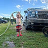 Landyn Scott joined the competition — help win amazing prizes! bicycle, child, clouds, daytime, fun, grass, greenery, joyful, nature, outdoor, playful, red_shoes, shorts, sky, summer, toddler, truck, vehicle, water_hose, water_splash