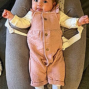 Alba participe au concours pour gagner de l'argent avec cette photo : baby, infant, romper, pink_clothing, white_socks, baby_seat, cushion, soft_texture, cute, playful, indoor, child, person, face, eyes, hands, legs, footwear, comfortable, resting