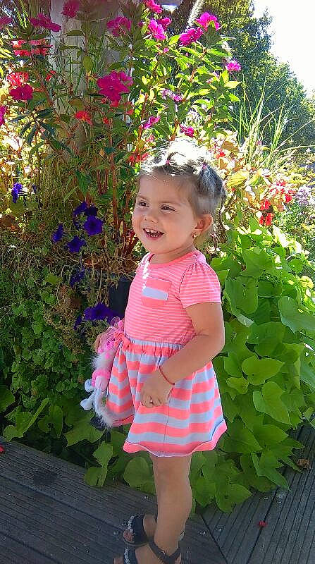 Selena participe au concours pour gagner de l'argent avec cette photo : baby_toddler_clothing, beauty, botany, child, day_dress, flower, grass, happy, joy, leaf, magenta, people_in_nature, person, petal, pink, plant, purple, shrub, sleeve, smile