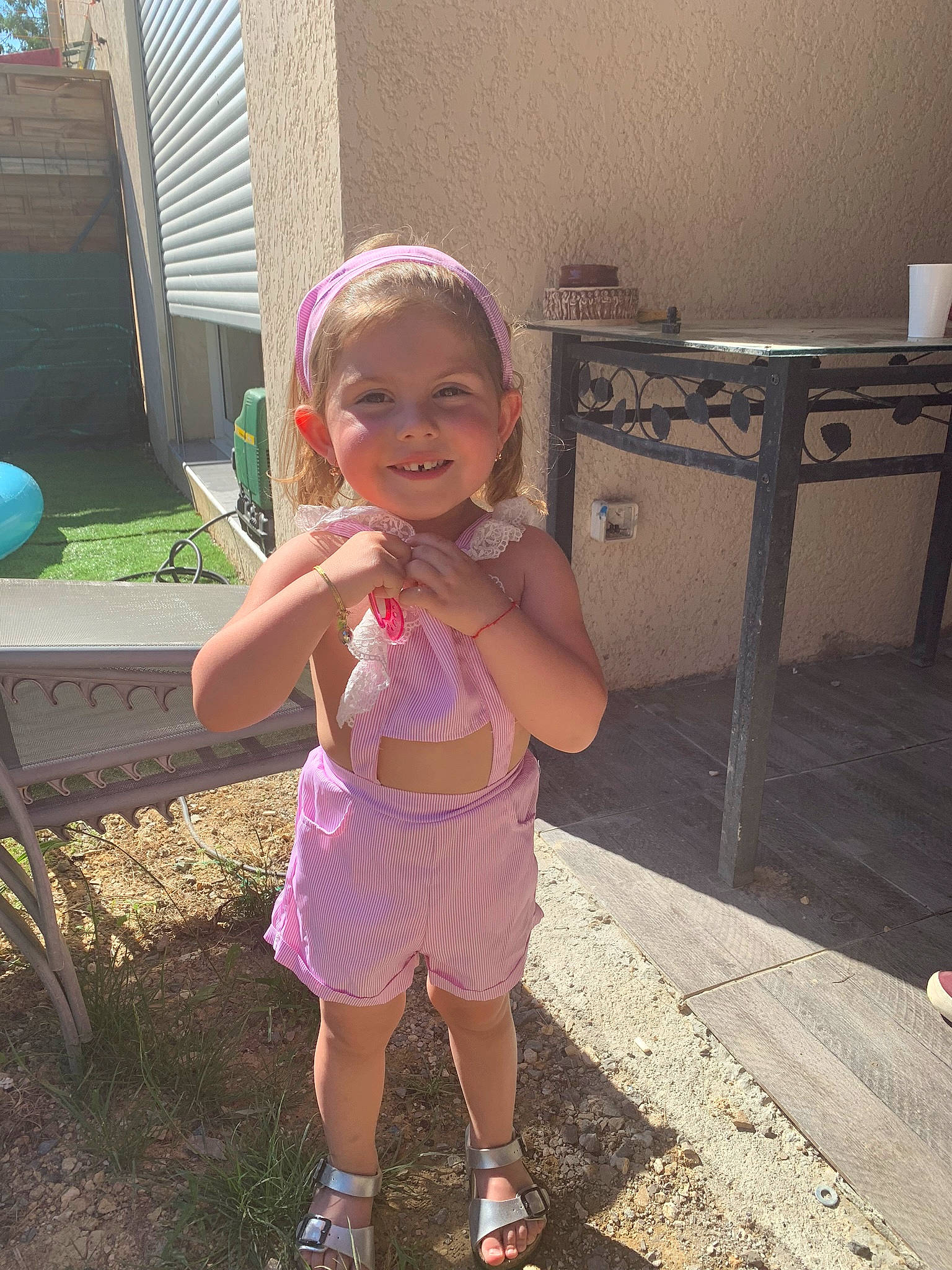 Selena participe au concours pour gagner de l'argent avec cette photo : baby_toddler_clothing, child, fun, grass, hairstyle, happy, human_leg, joy, leisure, magenta, person, pink, play, purple, recreation, sandal, sitting, smile, standing, thigh