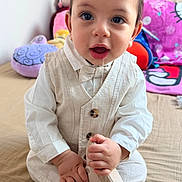 Anas a rejoint le concours — aidez-le/la à gagner de superbes lots ! baby, child, infant, cute, indoors, bed, clothing, vest, bow_tie, footwear, drool, hand, face, eyes, curious, sitting, toy, blanket, plush, portrait