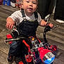 Liam is registered to the contest to win money with this photo: baby, clothing, face, footwear, hardwood, head, helmet, machine, motorcycle, motorscooter, pants, person, photography, portrait, scooter, shoe, transportation, vehicle, wheel, wood