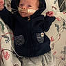 baby, infant, hospital, medical_tube, nasal_tube, blanket, footprint_pattern, clothing, hoodie, pants, bed, red_light, medical_device, person, lying_down, small_hands, small_feet, cute, indoors, healthcare