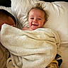 baby, blanket, face, pillow, smile, hair, person, bed, cozy, indoor, child, happy, cute, wrapped, texture, warm, resting, parent, toddler, comfort