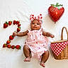 baby, infant, strawberry, balloon, picnic_basket, pink_clothing, headband, number_two, fruit, lying_down, white_background, cute, celebration, child, outdoor_theme, summer, food, red, checkered_pattern, portrait