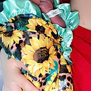 Rayleigh is registered to the contest to win money with this photo: newborn, baby, blanket, sunflower_pattern, mint_green, hand, fingers, sleeping, person, red_clothing, cradle, closeup, indoor, soft_light, peaceful, infant, wrapped, fabric, skin, portrait