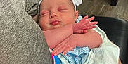 Rayleigh joined the competition — help win amazing prizes! baby, newborn, sleeping, bow, headband, blanket, person, arm, clothing, indoor, floor, chair, wood_floor, holding, peaceful, cute, infant, skin, resting, toddler
