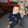 Ezra is registered to the contest to win money with this photo: toddler, pacifier, indoor, bench, barefoot, blue_eyes, couch, floral, clothing, child, person, furniture, carpet, toy, cabinet, shoes, notebook, blanket, room, casual