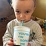 Levi is registered to the contest to win money with this photo: toddler, child, drink, cup, straw, blue_eyes, sweatshirt, indoor, toy, carpet, hand, face, person, casual_clothing, young_child, home, furniture, playroom, closeup, portrait