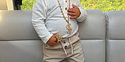 Taysem a rejoint le concours — aidez-le/la à gagner de superbes lots ! toddler, child, boy, pose, couch, window, white_shirt, beige_pants, white_sneakers, gold_chain, rings, spiky_hair, indoor, fashion, casual, curious, side_view, young_child, footwear, home