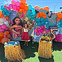 child, girl, balloons, birthday_party, moana, tropical, pineapples, coconuts, decorations, outdoor, sunlight, celebration, colorful, grass, dress, smile, festive, event, portrait, happy