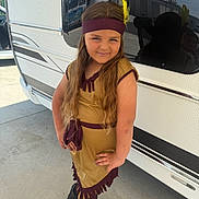 Haivy a rejoint le concours — aidez-le/la à gagner de superbes lots ! child, girl, costume, headband, feather, long_hair, brown_hair, posing, boots, outdoor, vehicle, reflection, concrete, smiling, hand_on_hip, dress, sunlight, casual, portrait, young_person