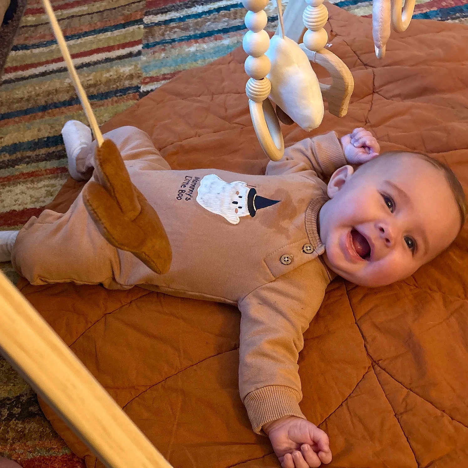 Paisleigh joined the competition — help win amazing prizes! baby, baby_gym, carpet, child, clothing, cute, face, floor, footwear, hand, happy, indoors, infant, onesie, playtime, quilt, skin, smiling, toy, wooden_frame