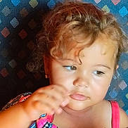 Novalynn joined the competition — help win amazing prizes! child, toddler, curly_hair, colorful_dress, patterned_background, portrait, indoor, person, young_child, face, skin, hand, sitting, expression, clothing, cute, young, head, shoulder, casual