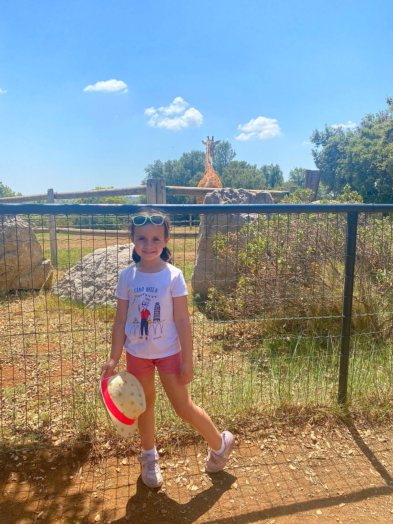 Chloé participe au concours pour gagner de l'argent avec cette photo : cloud, fence, grass, grassland, happy, hat, headwear, joy, knee, landscape, leisure, nature, people_in_nature, person, plant, recreation, shorts, sky, sneakers, summer