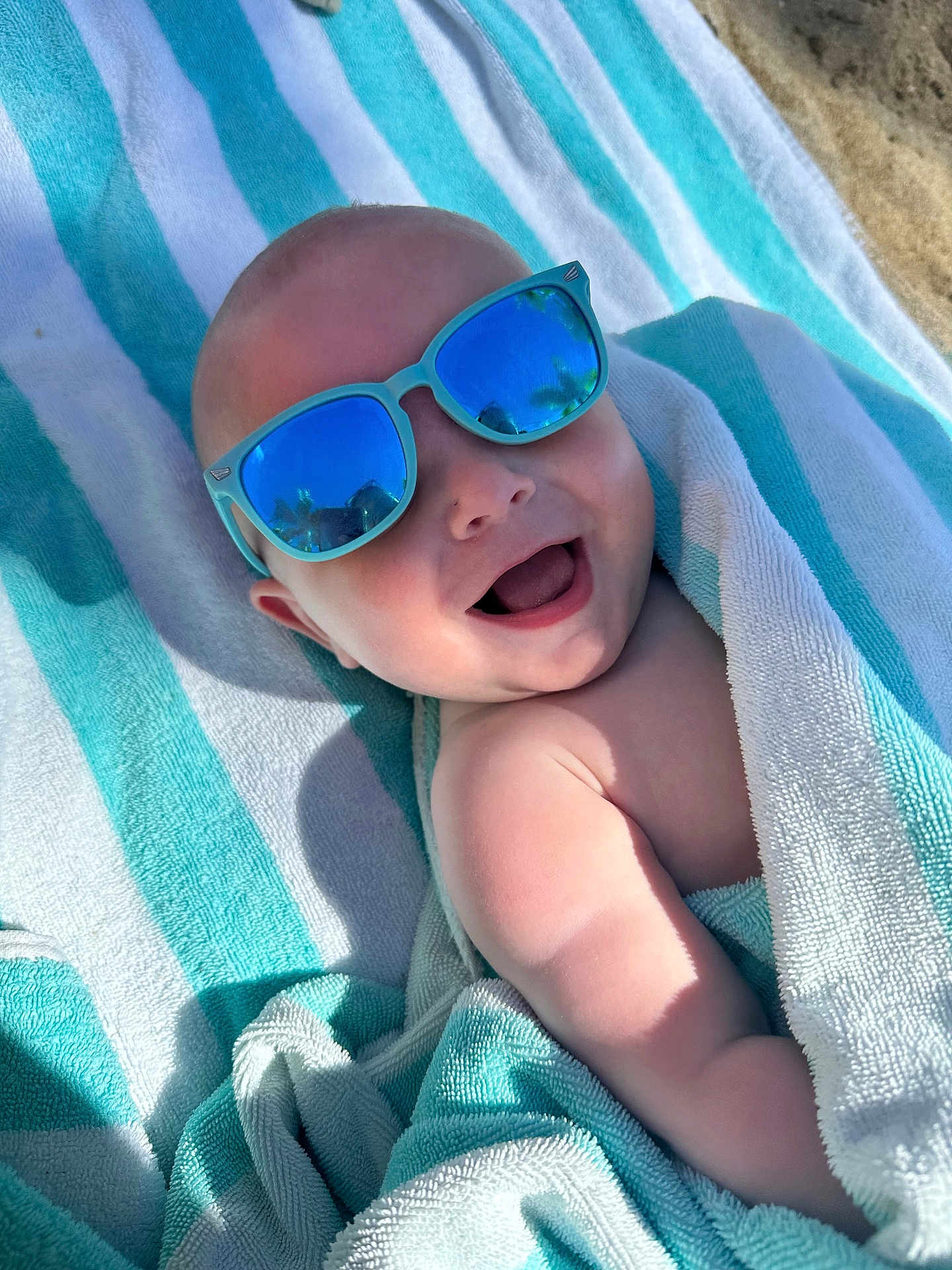 Heath joined the competition — help win amazing prizes! baby, child, towel, sunglasses, smiling, happy, outdoor, beach, sunlight, reflection, skin, head, arm, blanket, summer, cute, portrait, person, relaxing, fun