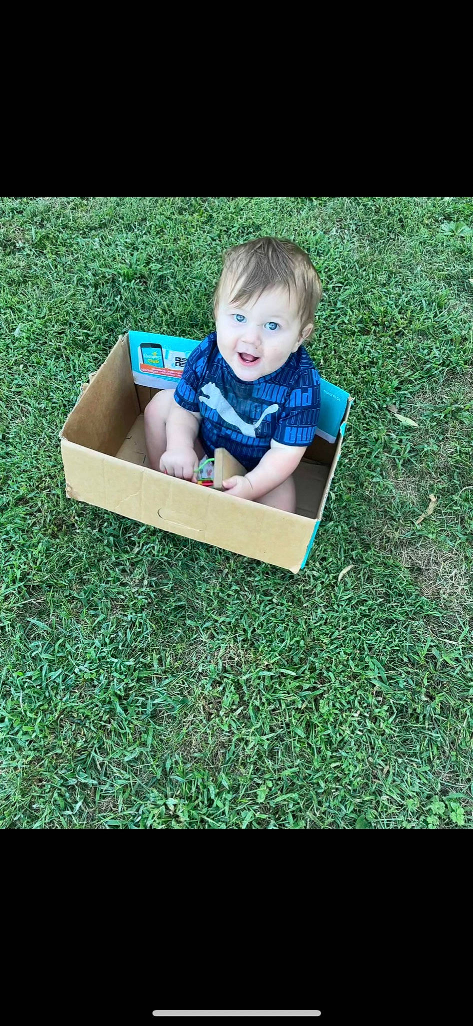 Lincoln is registered to the contest to win money with this photo: baby, baby_toddler_clothing, child, electric_blue, font, fun, grass, happy, lawn, leisure, outdoor_play_equipment, people_in_nature, person, play, recreation, rectangle, sitting, smile, soil, surprise