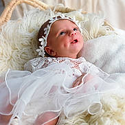 Dana participe au concours pour gagner de l'argent avec cette photo : baby, infant, white_dress, lace, headband, flower_crown, fluffy_blanket, basket, soft_texture, portrait, cute, newborn, sleeping_area, cozy, indoors, light, closeup, skin, child, peaceful