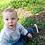 child, toddler, baby, face, outdoor, grass, leaves, plants, shoe, sneaker, jeans, sweater, anchor_badge, eyes, expression, portrait, sitting, curious, daylight, nature