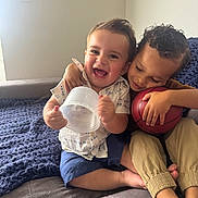 Jack joined the competition — help win amazing prizes! child, children, couch, indoor, smile, happy, toy, basketball, hug, sitting, clothing, shorts, shirt, curly_hair, light, blanket, foot, hand, face, family