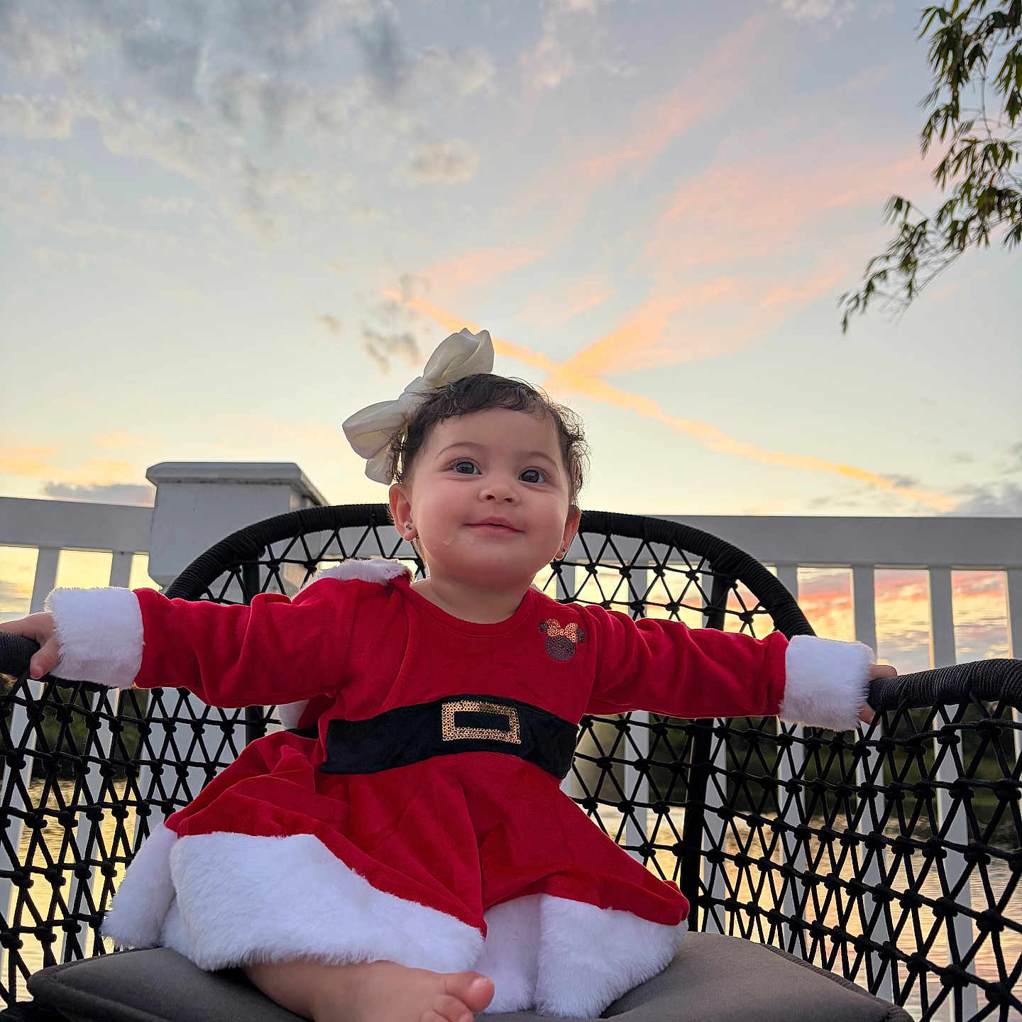 Blanca Sicilia joined the competition — help win amazing prizes! baby, barefoot, bow, chair, child, clouds, curly_hair, cushion, dress, face, fence, hair_accessory, happy, outdoor, portrait, red_clothing, sky, smile, sunset, white_fur_trim