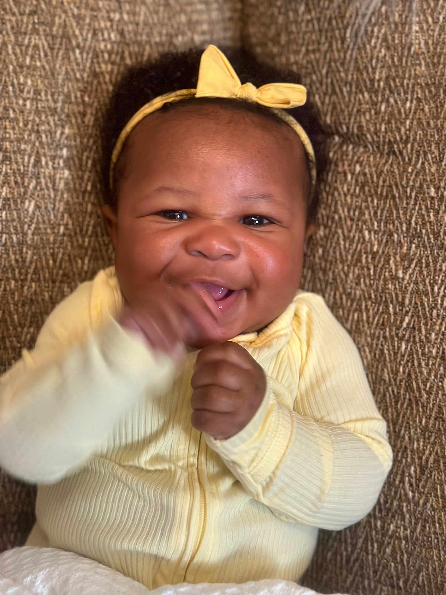 Khyla joined the competition — help win amazing prizes! baby, child, smiling, yellow_headband, yellow_clothing, happy, portrait, indoor, cute, infant, hands, face, young_child, sitting, texture_background, close_up, joyful, expressive, human, candid