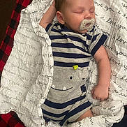 Jahkarri is registered to the contest to win money with this photo: baby, sleeping, pacifier, striped_clothing, blanket, text_pattern, smiling_hippo, infant, cute, cozy, soft_fabric, child, toddler, sleepwear, napping, indoors, comfort, peaceful, red_black_checkered, white