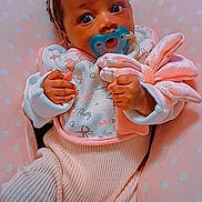 Khalani is registered to the contest to win money with this photo: baby, infant, child, portrait, lying_down, pacifier, bow, blanket, pink, polka_dots, cushion, leopard_print, clothing, hands, wide_eyes, indoor, cozy, cute, sleepwear, photography