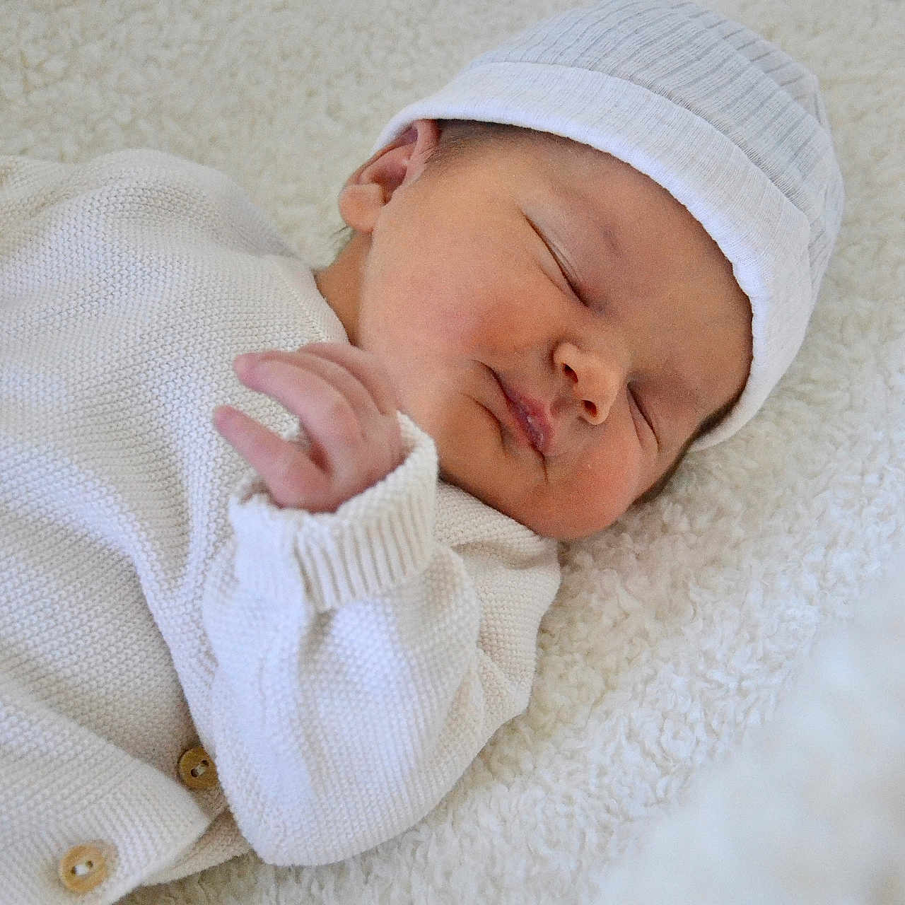 Lilou participe au concours pour gagner de l'argent avec cette photo : baby, blanket, child, closeup, cozy, cute, face, hands, hat, indoors, infant, knitwear, newborn, peaceful, portrait, resting, sleeping, soft_texture, warm, white_clothing