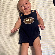 Luke joined the competition — help win amazing prizes! baby, infant, smiling, romper, football_emblem, blanket, white, cute, chubby_cheeks, lying_down, hands, legs, socks, skin, happy, child, portrait, indoors, closeup, person