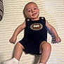 Luke is registered to the contest to win money with this photo: baby, infant, smile, romper, football_emblem, white_socks, blanket, texture, lying_down, happy, child, cute, indoor, person, skin, head, arms, legs, clothing, portrait