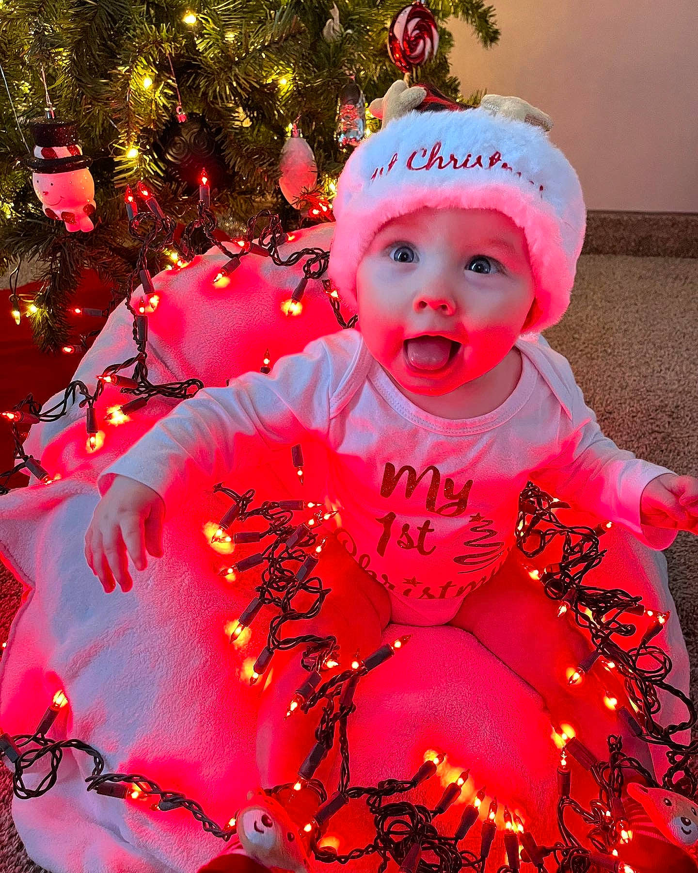 Oaklynn Rae joined the competition — help win amazing prizes! baby, baby_toddler_clothing, christmas_decoration, christmas_ornament, christmas_tree, event, eye, face, happy, headwear, holiday, human_body, light, magenta, ornament, person, pink, plant, surprise, toddler