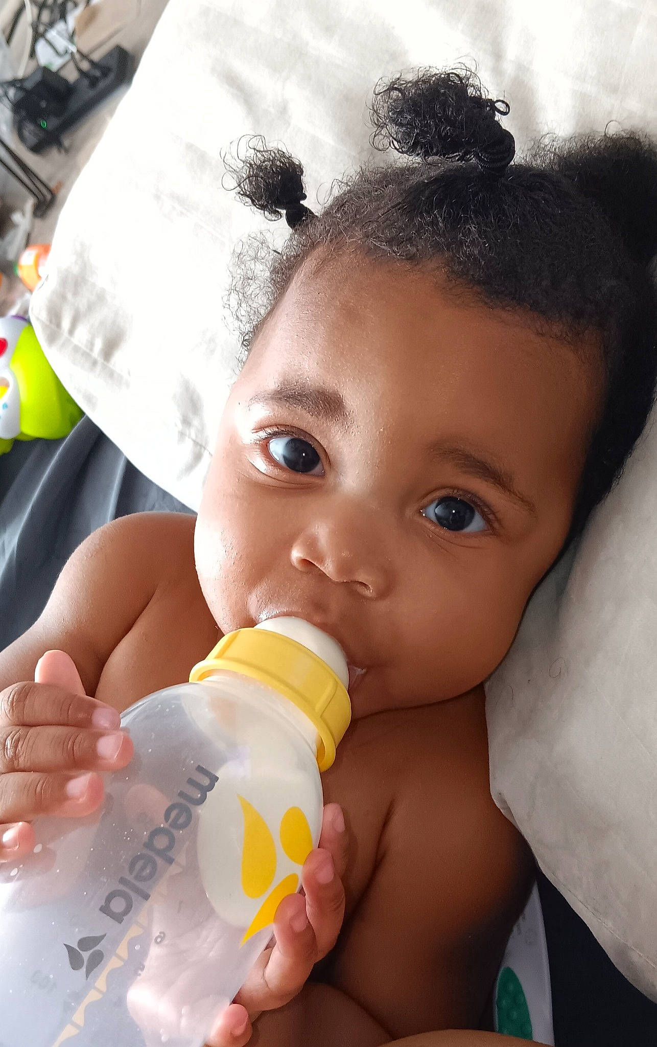 Micica is registered to the contest to win money with this photo: baby_bottle, cheek, drinkware, ear, eyelash, face, finger, gesture, hairstyle, hand, happy, head, lip, nail, nose, organ, person, skin, thumb, toddler