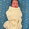 Azraël is registered to the contest to win money with this photo: newborn, baby, infant, sleeping, swaddled, blanket, portrait, face, closed_eyes, peaceful, indoors, blue_background, rocket_pattern, bedding, cream_clothing, lying_down, calm, cute, photography, nursery