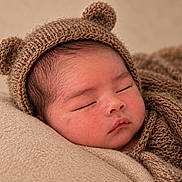 Azraël is registered to the contest to win money with this photo: newborn, baby, sleeping, portrait, close_up, face, knit_hat, bear_hat, blanket, swaddled, cozy, indoors, infant, peaceful, closed_eyes, warm_tones, textile, soft_lighting, candid, nursery