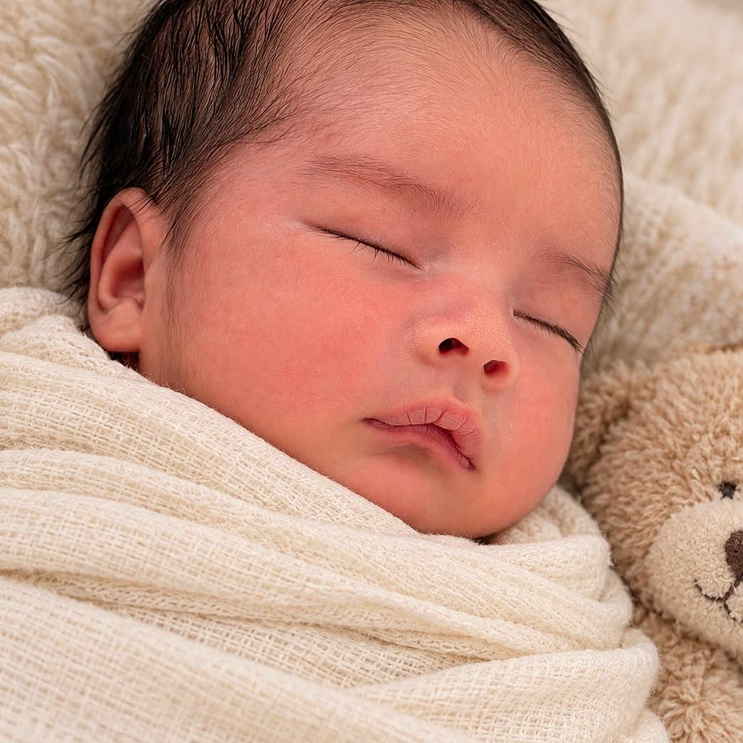 Azraël is registered to the contest to win money with this photo: newborn, baby, sleeping, swaddled, blanket, teddy_bear, plush_toy, portrait, close_up, face, closed_eyes, peaceful, cozy, indoors, soft_lighting, warm_tones, infant, nursery, snuggled, photography