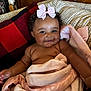 baby, blanket, child, couch, cozy, curly_hair, cute, drool, face, happy, indoor, infant, pillow, pink_bow, portrait, relax, skin, smile, soft_texture, warm