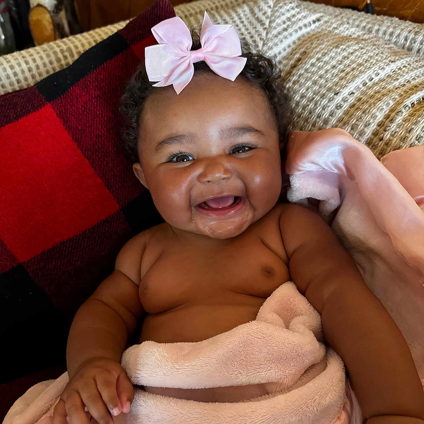 Zalayna is registered to the contest to win money with this photo: baby, blanket, cheeks, child, couch, cozy, curly_hair, cute, drool, happy, indoors, infant, pillow, pink_bow, portrait, red_and_black, relaxing, skin, smiling, toddler