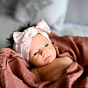 Míkah joined the competition — help win amazing prizes! baby, infant, headband, bow, blanket, wrapped, soft, cute, portrait, indoors, newborn, child, face, expression, gaze, cozy, skin, sleepy, resting, young